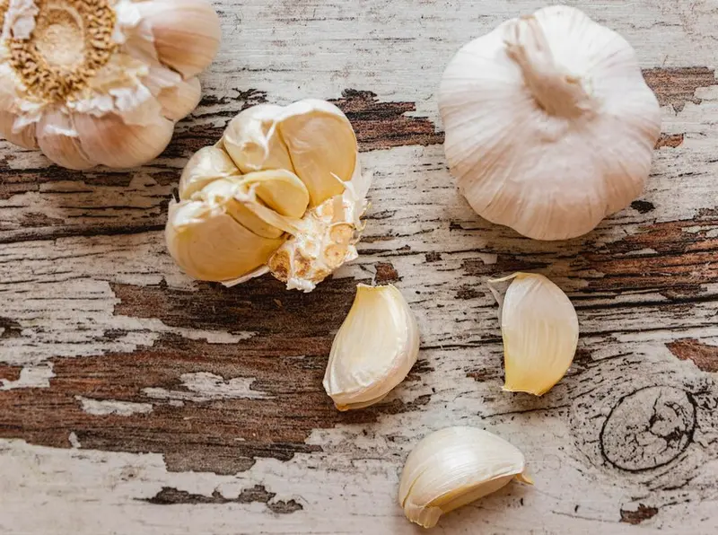 Główki i ząbki czosnku na stole / fot. freepik freepik.com
