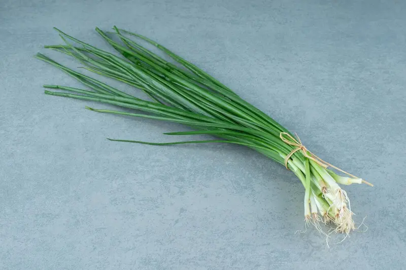 Pęczek świeżego szczypiorku na stole / fot. azerbaijan_stockers freepik.com